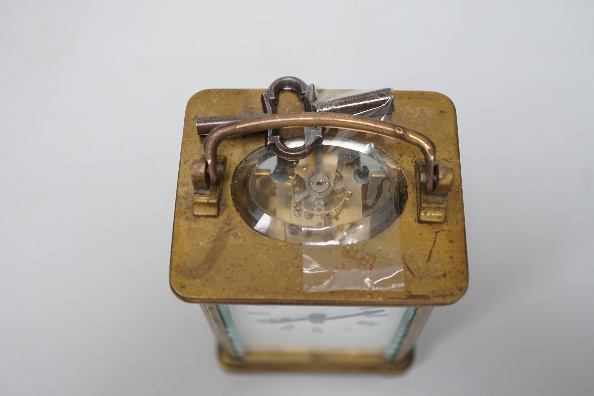 A 19th century brass carriage timepiece with black Roman numerals and second markers over a white dial